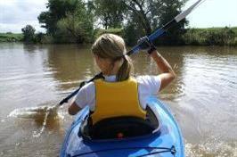 Girl kayaking in a calm river.